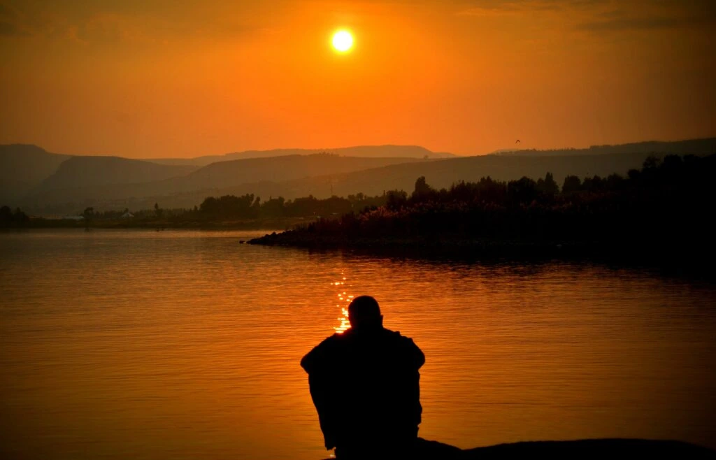 Solo traveller sitting near sun set